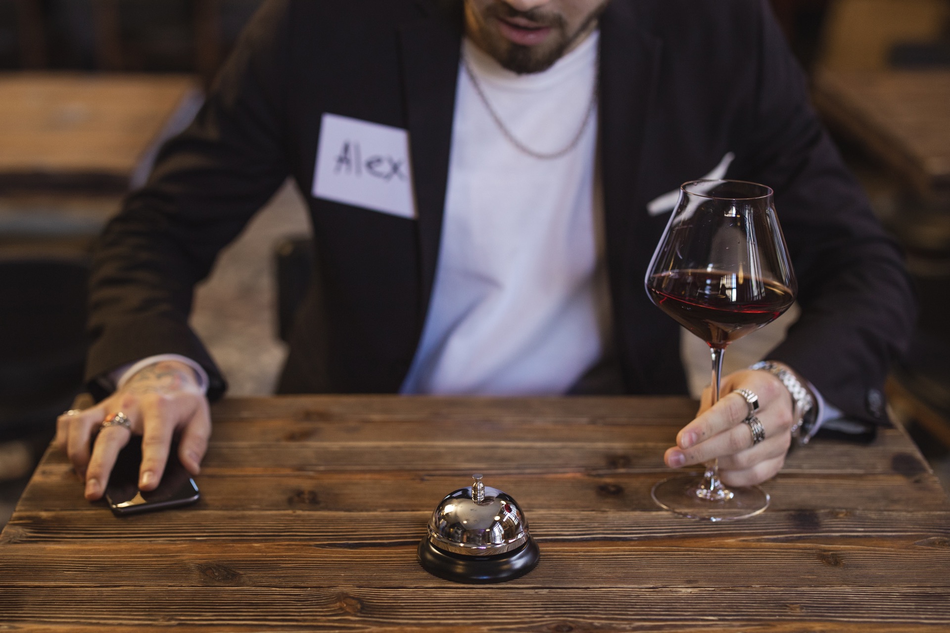 A candid moment from a Datespace evening: a name tag beside a glass of wine on a warm wooden table